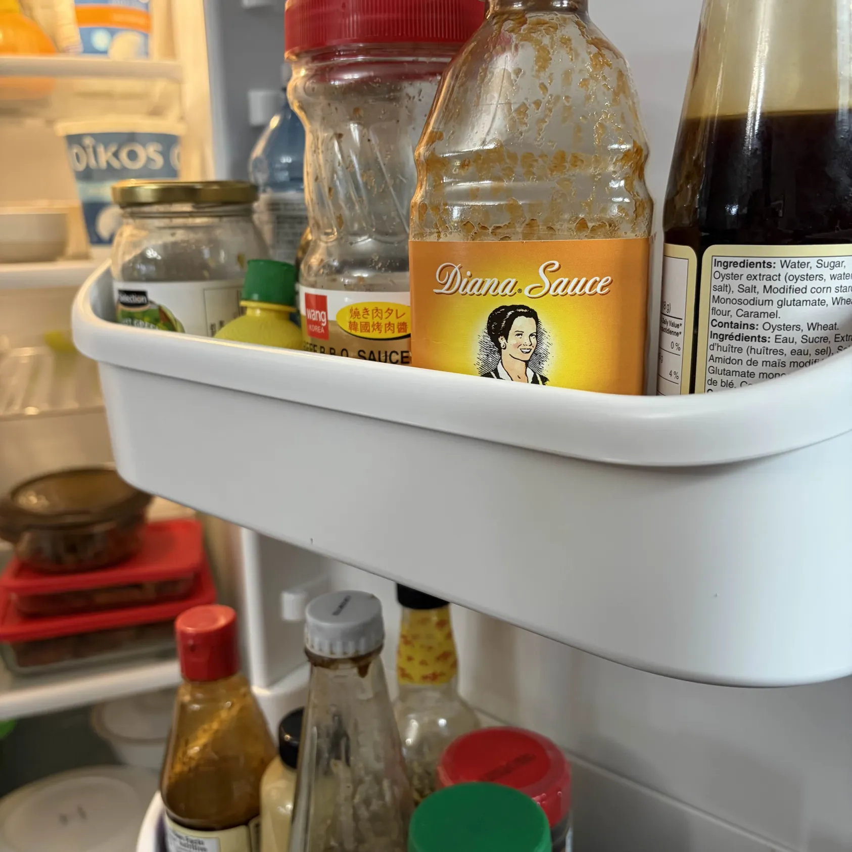 The rustling of glass containers inside the fridge.
