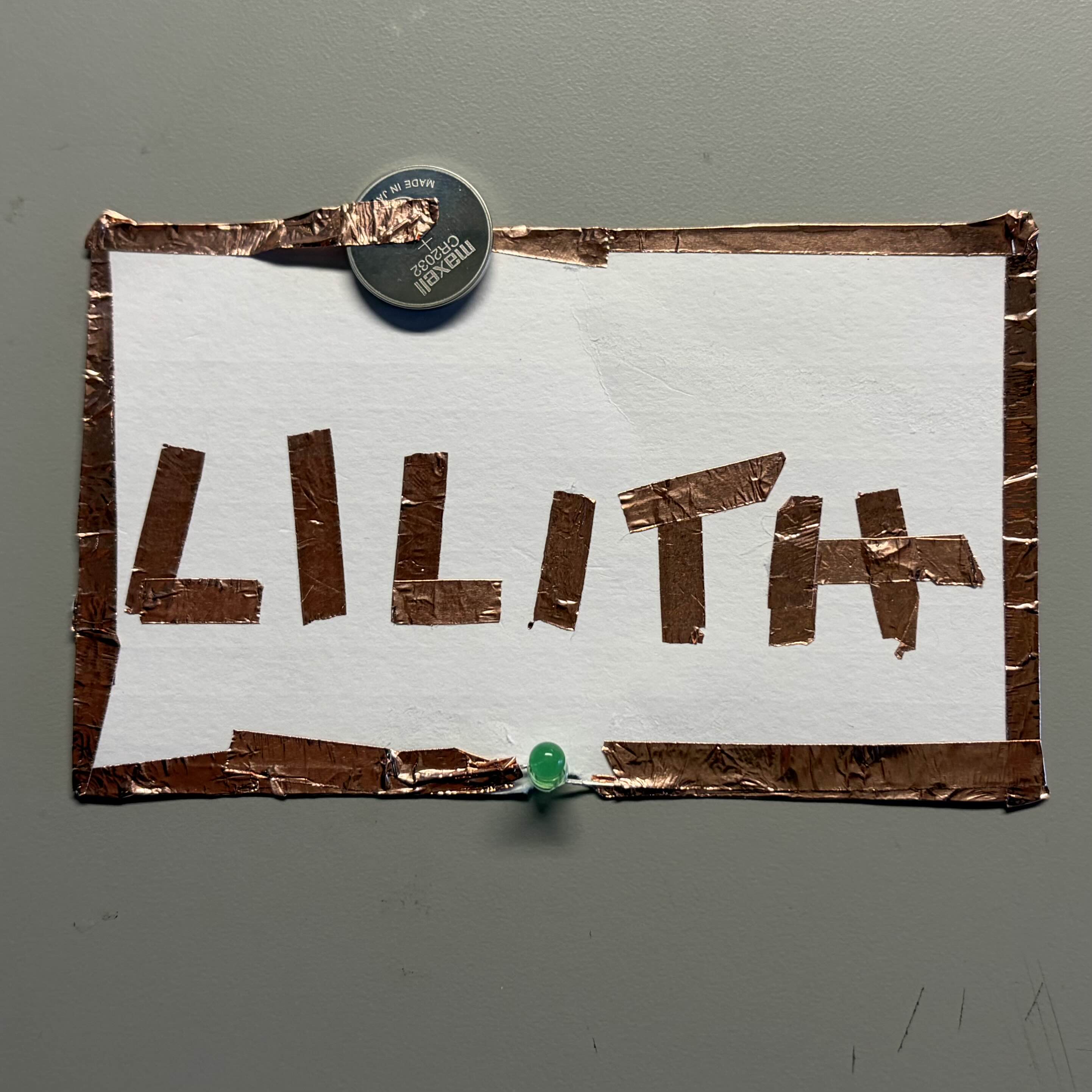 Experimenting with copper wire taped around the edges of the paper. Connection is faulty