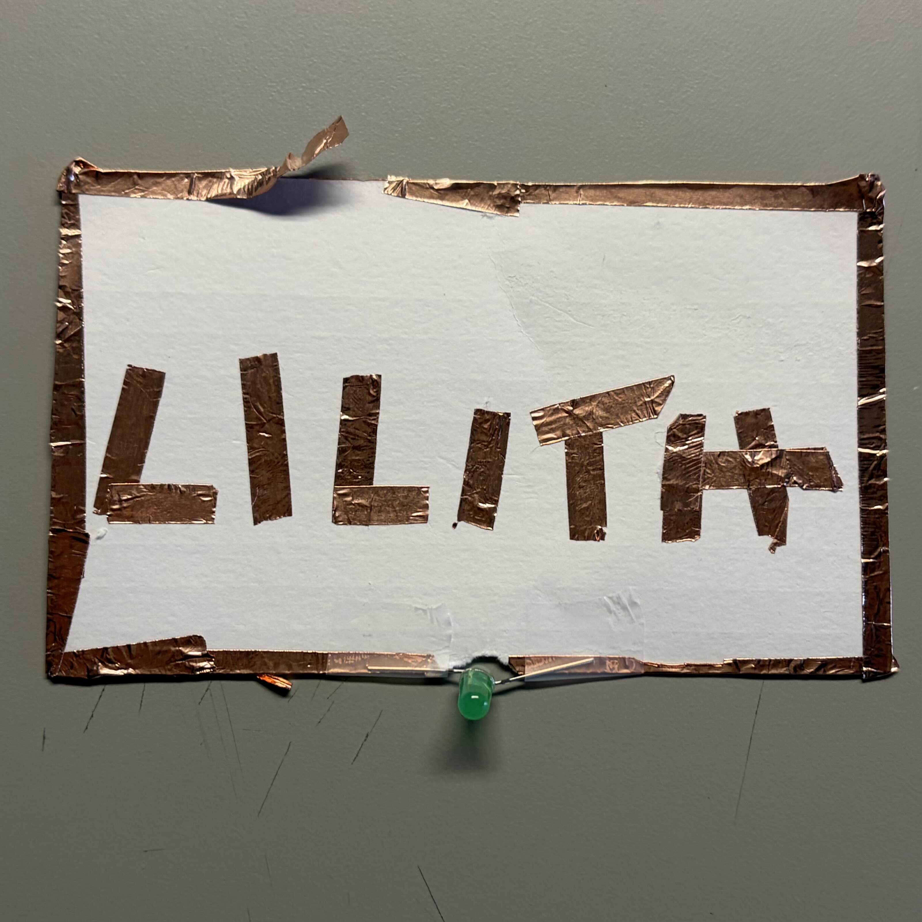 Experimenting with copper wire taped around the edges of the paper. Connection is faulty